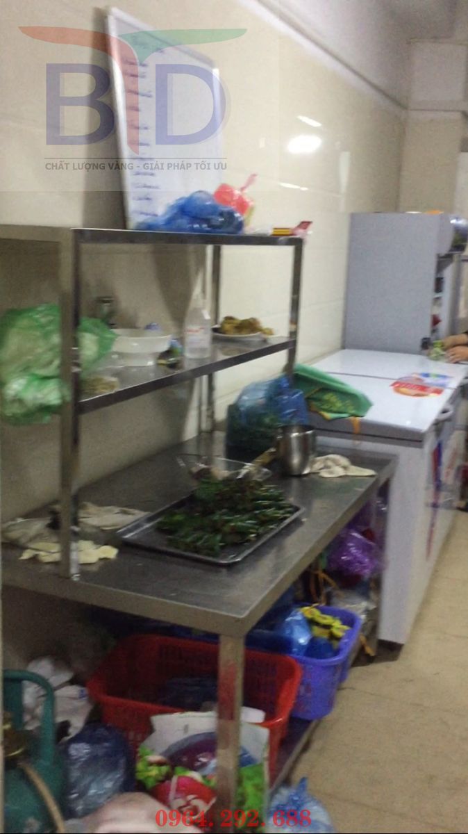 Bàn inox phẳng có 1 giá nan dưới kết hợp với giá kệ thanh 2 tầng trên  tại khu bếp Trung tâm hội nghị tỉnh Cao Bằng